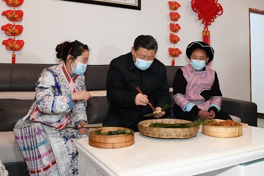 2021年2月3日下午，習(xí)近平在貴州畢節(jié)市黔西縣新仁苗族鄉(xiāng)化屋村苗族村民趙玉學(xué)家，同一家人邊聊家常邊制作當(dāng)?shù)貍鹘y(tǒng)節(jié)日食品黃粑。新華社記者 李學(xué)仁 攝