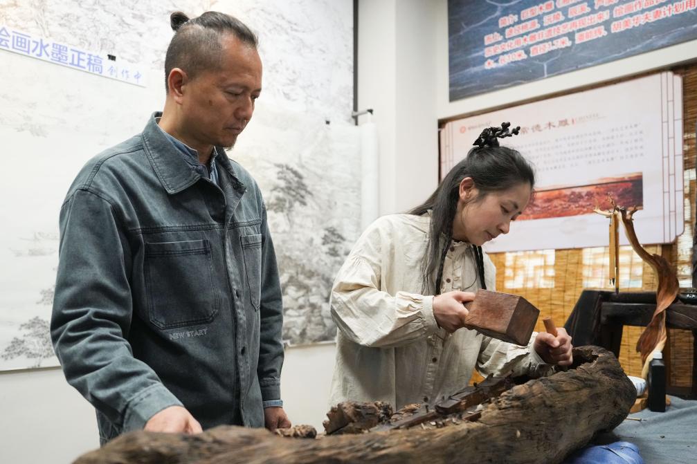 潘能輝和妻子胡美華在湖南常德河街展示木雕。新華社記者 薛宇舸 攝